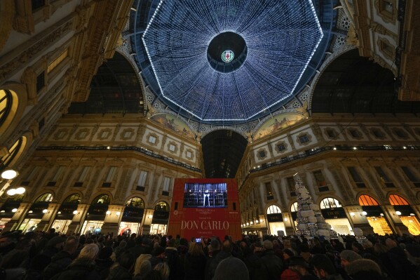 Spectators gathering in the Galleria Vittorio Emanuele II watch on a screen Giuseppe Verdi's opera 'Don Carlo' at the Milan La Scala theater, Italy, Thursday Dec. 7, 2023. The season-opener Thursday, held each year on the Milan feast day St. Ambrose, is considered one of the highlights of the European cultural calendar. (AP Photo/Luca Bruno)