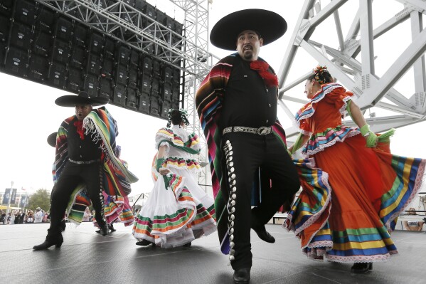 FILE - Members of a Ballet Folklorico perform outside AT&T stadium as part of the Hispanic Heritage Month celebration before an NFL football game between the New Orleans Saints and Dallas Cowboys, Sept. 28, 2014, in Arlington, Texas. Hispanic history and culture take center stage across the U.S. for National Hispanic Heritage Month. The celebration recognizes contributions made by Hispanic Americans, the fastest-growing racial or ethnic minority according to the Census, and with a U.S. population of over 63 million people, there will be a plethora of Hispanic Heritage Month celebrations all over the country starting Friday, Sept. 15, 2023. (AP Photo/Brandon Wade, File)