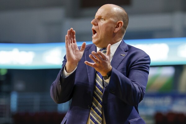 FILE - Northern Arizona head coach Shane Burcar cheers on his defense during the first half of an NCAA college basketball game against Montana State in the championship of the Big Sky men's tournament in Boise, Idaho, Wednesday, March 8, 2023. With a healthy roster and nearly everyone back from last year's team, the Lumberjacks are fully expecting a run at a Big Sky championship. (AP Photo/Steve Conner, File)