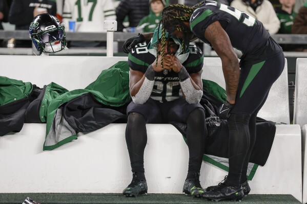New York Jets running back Breece Hall (20) and linebacker Quincy Williams (56) talk on the bench after an NFL football game against the Miami Dolphins, Friday, Nov. 24, 2023, in East Rutherford, N.J. (AP Photo/Adam Hunger)