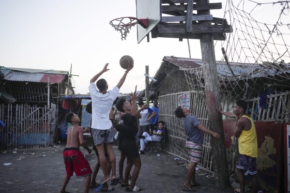 Residents play basketball in a coastal village Tuesday, Aug. 8, 2023, in Batangas province, Philippines. (AP Photo/Aaron Favila)