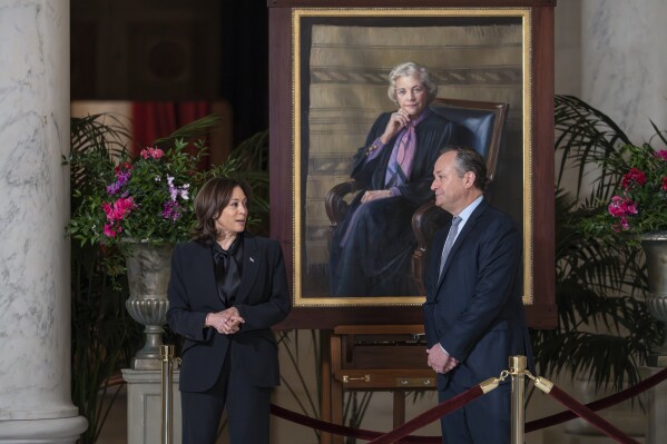 CORRECTS EMHOFF TO SECOND GENTLEMEN INSTEAD OF FIRST - Vice President Kamala Harris, left, and second gentleman Doug Emhoff pay their respects as they walk past a portrait of retired Supreme Court Justice Sandra Day O'Connor as her casket lies in the Great Hall at the Supreme Court in Washington, Monday, Dec. 18, 2023. O'Connor, an Arizona native and the first woman to serve on the nation's highest court, died Dec. 1 at age 93. (AP Photo/J. Scott Applewhite)