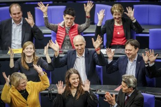 Lawmaker Heike Heubach, front center, the first deaf member of the Bundestag, sits between members of the faction of the German Social Democrats (SPD) at the start of a meeting of the German federal parliament, Bundestag, at the Reichstag building in Berlin, Germany, Thursday, March 21, 2024. The German parliament on Thursday welcomed its first deaf lawmaker, who took her place in a development that the house's speaker described as historic. Heike Heubach narrowly missed out on a seat in the Bundestag, in Germany's 2021 election. But she joined the house this week as a replacement for Uli Groetsch. (Kay Nietfeld/dpa via AP)