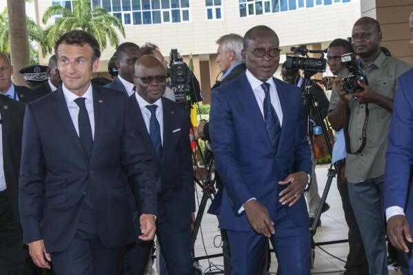 French President Emmanuel Macron, left, is welcomed by Benin President Patrice Talon at the presidency in Cotonou Wednesday July 27, 2022. Macron is on a three-country tour to improve relations with the nations of west and central Africa. Benin is his second leg of the journey after visiting Cameroon. (AP Photo/David Gnaha)