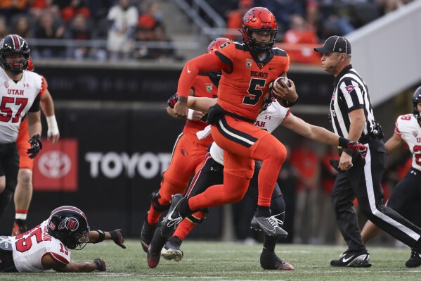 Oregon State quarterback DJ Uiagalelei (5) dodges Utah cornerback Tao Johnson (15) during the first half of an NCAA college football game Friday, Sept. 29, 2023, in Corvallis, Ore. (AP Photo/Amanda Loman)