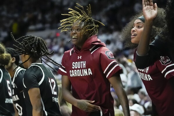 FILE - South Carolina forward Sahnya Jah, center, celebrates on the bench in the second half an NCAA college basketball game against LSU in Baton Rouge, La., Thursday, Jan. 25, 2024. South Carolina suspended freshman forward Sahnya Jah has entered the transfer portal. Jah was suspended on Feb. 8 for conduct detrimental to the team. Gamecocks coach Dawn Staley would not give more details about Jah's suspension, saying the player could work her way back on the team. Staley announced Jah's latest move Monday, March 18, 2024. (AP Photo/Gerald Herbert, File)