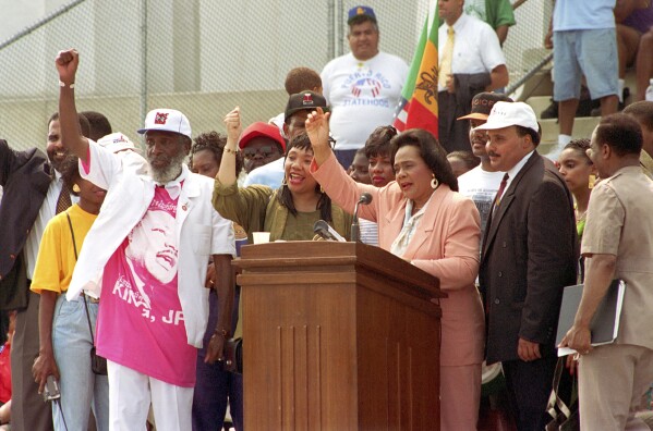 FILE - Coretta Scott King, at podium, widow of slain civil rights leader the Rev. Martin Luther King Jr., acknowledges the crowd gathered for the Civil Rights March at Lincoln Memorial in Washington on Aug. 28, 1993. Standing with King are Dick Gregory, left, and two of her children. (AP Photo/Dennis Cook, File)