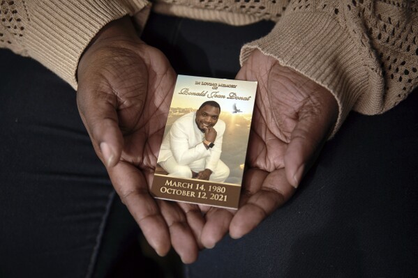 Widow Sharline Volcy holds a picture of her deceased husband, Roland Donat, Monday, Feb. 3, 2025, in Orange, N.J. (AP Photo/Andres Kudacki)