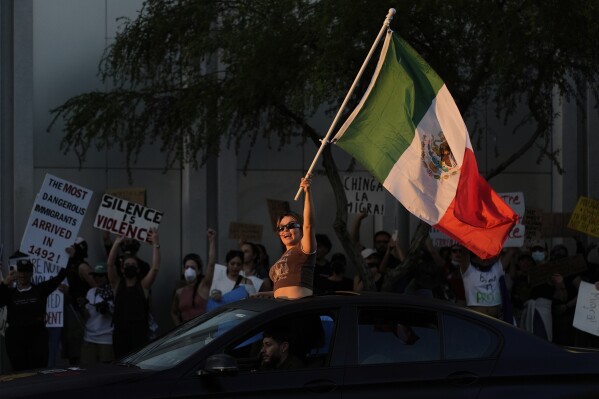 A woman waves a Mexican flag during protests over President Donald Trump's stepped-up enforcement of immigration laws, Wednesday, June 11, 2025, in Las Vegas. (AP Photo/John Locher)
