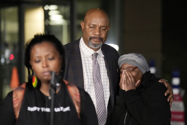 Sheneen McClain, right, is consoled by Omar Montgomery, president of the Aurora NAACP, as Midian Holmes, a friend of McClain, speaks outside the Adams County Colo., Justice Center, after a verdict was rendered in the killing of her son Elijah McClain, Friday, Dec. 22, 2023, in Brighton, Colo. Two paramedics were convicted in the 2019 killing of McClain, who they injected with an overdose of the sedative ketamine after police put him in a neck hold. (AP Photo/David Zalubowski)