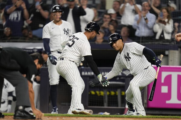 New York Yankees' Gleyber Torres (25), center, celebrates after his home run with Juan Soto, right, during the first inning of a baseball game against the Boston Red Sox at Yankee Stadium, Thursday, Sept. 12, 2024, in New York. (AP Photo/Seth Wenig)