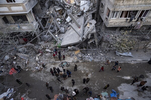 Palestinos inspeccionan los daños a edificios residenciales después de un ataque aéreo israelí en Rafah, en el sur de la Franja de Gaza, el domingo 24 de marzo de 2024. (Foto AP/Fatima Shbair)