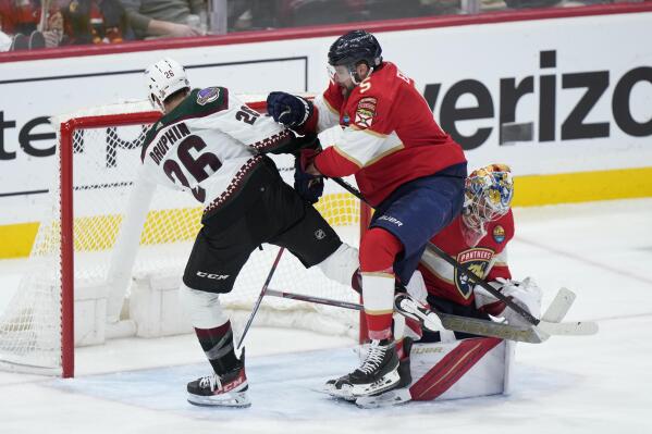 Florida Panthers defenseman Aaron Ekblad (5) pushes Arizona Coyotes center Laurent Dauphin (26) out of the way as goaltender Spencer Knight, right rear, makes a save during the second period of an NHL hockey game, Tuesday, Jan. 3, 2023, in Sunrise, Fla. (AP Photo/Wilfredo Lee)