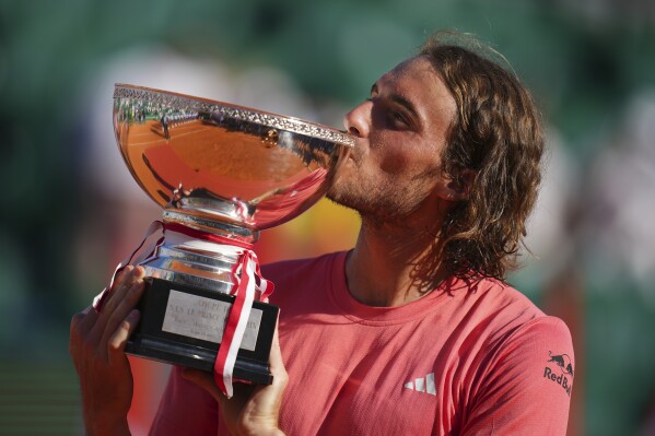Stefanos Tsitsipas of Greece kisses the trophy after defeating Casper Ruud of Norway to win the Monte Carlo Tennis Masters final match 6-1, 6-4 in Monaco, Sunday, April 14, 2024. (AP Photo/Daniel Cole)