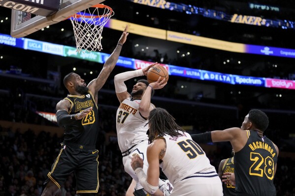 Denver Nuggets guard Jamal Murray (27) drives to the basket against Los Angeles Lakers forward LeBron James (23) during the second half of an NBA basketball game in Los Angeles, Thursday, Feb. 8, 2024. (AP Photo/Eric Thayer)