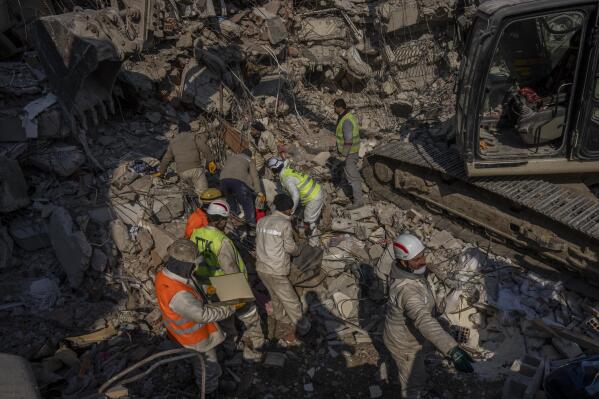 FILE - Members of a search and rescue team work on a collapsed structure after the earthquake in Antakya, southeastern Turkey, Sunday, Feb. 12, 2023. Starting Monday, a crucial Twitter tool known as Application Developer Interface, used by software developers to comb the platform for calls for help from earthquake victims, may be accessible only by paying a $100 monthly fee. (AP Photo/Bernat Armangue, File)