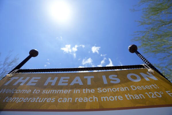 Patrons are warned about the heat at the Desert Botanical Garden entrance, Wednesday, Aug. 2, 2023, in Phoenix. (AP Photo/Ross D. Franklin)