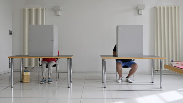 People fill in their ballots, at the absentee ballot office, in Nordhausen town hall, in Nordhausen, Germany, Tuesday, Sept. 19, 2023. The German city of Nordhausen is best known as the location of the former Nazi concentration camp Mittelbau-Dora. A mayoral election on Sunday, Sept, 24, 2023 could again put the focus on the municipality of 42,000 people if a far-right candidate wins the vote. (Martin Schutt/dpa via AP)