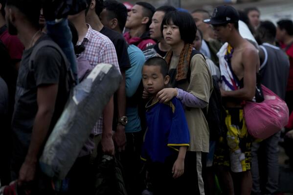 Chinese migrants line up to take a boat to Lajas Blancas after walking across the Darien Gap in Bajo Chiquito, Panama, Sunday, May 7, 2023. (AP Photo/Natacha Pisarenko)