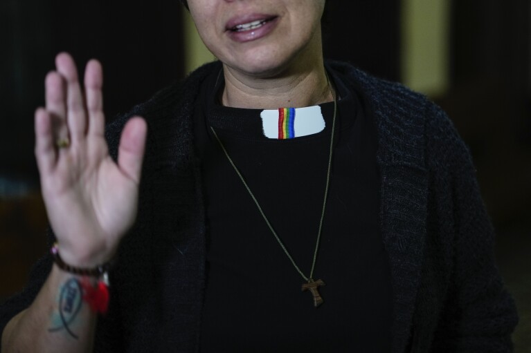 Rev. Elaine Saralegui, wearing a rainbow flag on her clerical collar, talks at the end of a service at the Metropolitan Community Church, an LGBTQ+ inclusive house of worship, in Matanzas, Cuba, Friday, Feb. 2, 2024. “This church is a family,” said Saralegui, who has a tattoo of the Jesus fish on one of her forearms and wears a Buddhist bracelet. (AP Photo/Ramon Espinosa)