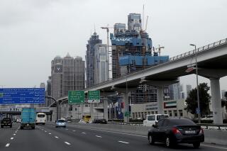 FILE - In this Feb. 11, 2020, file photo, cars pass by the under construction DAMAC towers on Sheikh Zayed highway in Dubai, United Arab Emirates. A Dubai real-estate company DAMAC Properties, known for its deals with former President Donald Trump, said, Thursday, Sept. 23, 2021, it has received regulator approval for an effort to take the firm private. (AP Photo/Kamran Jebreili, File)