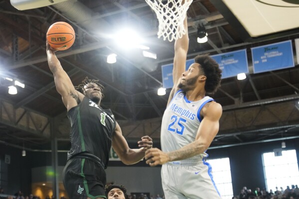Tulane guard Sion James (1) goes to the basket against Memphis guard Jayden Hardaway (25) during the first half of an NCAA college basketball game in New Orleans, Sunday, Jan. 21, 2024. (AP Photo/Gerald Herbert)