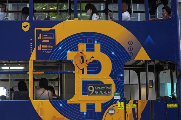 FILE - An advertisement for the cryptocurrency Bitcoin displayed on a tram, May 12, 2021, in Hong Kong. U.S. regulators are soon expected to decide whether to approve the first bitcoin exchange-traded fund, a development that could thrust the once niche and nerdy corner of the internet even further into the financial mainstream. (AP Photo/Kin Cheung, File)