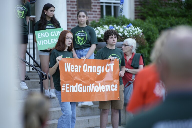 Les membres de la Junior Newtown Action Alliance tiennent des pancartes lors d'un rassemblement contre la violence armée le vendredi 7 juin 2024 à Newtown, Connecticut.  (Photo AP/Bryan Woolston)