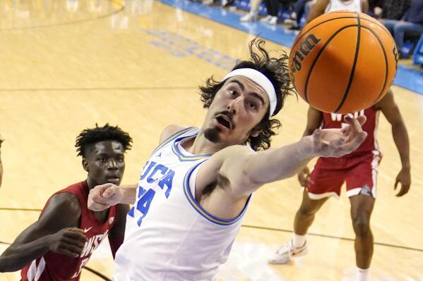 FILE - UCLA guard Jaime Jaquez Jr., right, reaches for a rebound as Washington State forward Mouhamed Gueye watches during the first half of an NCAA college basketball game Saturday, Feb. 4, 2023, in Los Angeles. Jaquez was named The Associated Press player of the year in the Pac-12 Conference on Tuesday, March 7, 2023. (AP Photo/Mark J. Terrill, File)