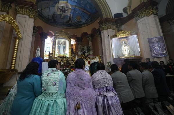 Devotees pray after dressing the statue of "Jesus del Gran Poder" or Lord of Great Power, at the "Jesus del Gran Poder" church in La Paz, Bolivia, Thursday, June 1, 2023. Thousands of dancers and musicians will parade on Saturday to show their devotion and thank God and for the year's blessings. (AP Photo/Juan Karita)