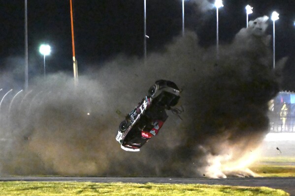 FILE - Ryan Preece barrel rolls along the back stretch during a NASCAR Cup Series auto race at Daytona International Speedway, Aug. 26, 2023, in Daytona Beach, Fla. Preece might not recognize the spot where his harrowing crash started at the speedway last August. NASCAR paved over the grassy area that seemingly caused Preece’s car to become airborne and roll about a dozen times during the 400-mile summer race at the famed track. (AP Photo/Don Howard, File)