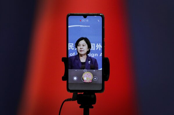 FILE - In this Sept. 1, 2020 file photo, a smartphone records Chinese Foreign Ministry spokeswoman Hua Chunying as she speaks during a daily briefing at the Ministry of Foreign Affairs in Beijing. "I'd like to stress that if the United States truly respects facts, it should open the biological lab at Fort Detrick, give more transparency to issues like its 200-plus overseas bio-labs, invite WHO experts to conduct origin-tracing in the United States," she said at a January 2021 MOFA press conference that went viral in China. (AP Photo/Andy Wong)