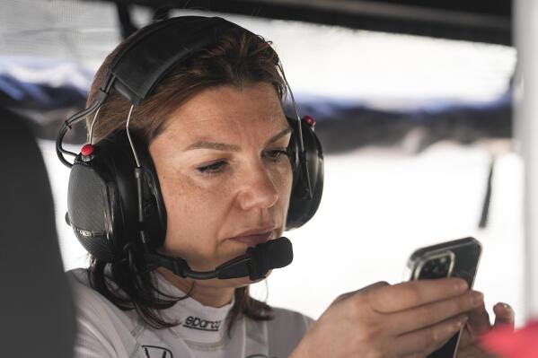 Katherine Legge, of England, looks at her phone before practice for the Indianapolis 500 auto race at Indianapolis Motor Speedway, Thursday, May 25, 2023, in Indianapolis. (AP Photo/Darron Cummings)