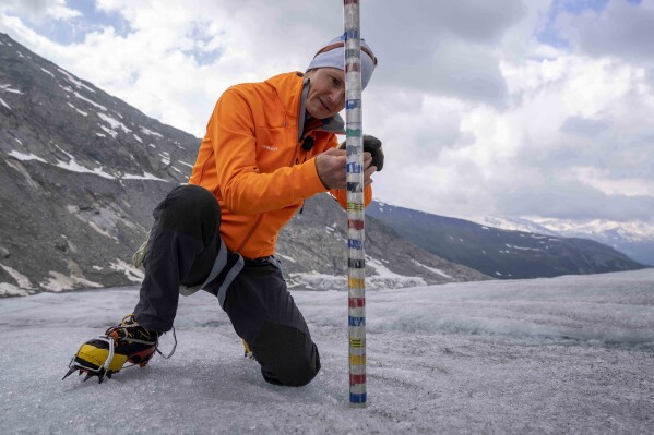 FILE - ETH (Swiss Federal Institute of Technology) glaciologist and head of the Swiss measurement network Glamos, Matthias Huss, checks the thickness of the Rhone Glacier near Goms, Switzerland, June 16, 2023. (AP Photo/Matthias Schrader, File)