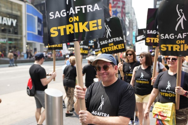 FILE - Actor Jason Kravits carries a sign on a picket line outside Paramount in Times Square in New York on July 17, 2023. (Photo by Charles Sykes/Invision/AP)