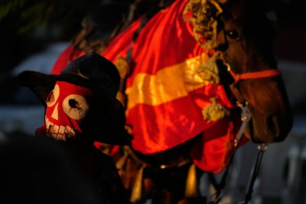 Un juerguista enmascarado y su caballo participan en las Cavalhadas, o Festival del Espíritu Santo, en Pirenópolis, estado de Goiás, Brasil, el domingo 8 de junio de 2025. (Foto AP/Eraldo Peres)