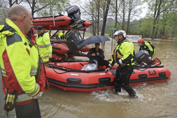 A resident is brought to dry land by boat after being rescued from flood waters by emergency responders from the Benton, Conway and Shannon Hills fire departments and the Pulaski County Emergency Management team in Shannon Hills, Ark., Saturday, April 5, 2025, as a second day of storms brought widespread flooding to the region. (Colin Murphey/Arkansas Democrat-Gazette via AP)