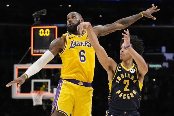 Indiana Pacers guard Andrew Nembhard, right, makes a buzzer beating 3-point shot to win the game as Los Angeles Lakers forward LeBron James defends during the second half of an NBA basketball game Monday, Nov. 28, 2022, in Los Angeles. The Pacers won 116-115. (AP Photo/Mark J. Terrill)