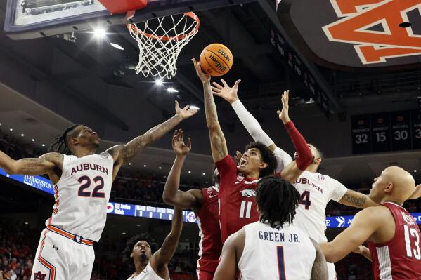 Arkansas forward Jalen Graham (11) tries to put up a shot as Auburn guard Allen Flanigan (22) and Auburn forward Johni Broome (4) try and block during the first half of an NCAA college basketball game Saturday, Jan. 7, 2023, in Auburn, Ala. (AP Photo/Butch Dill)