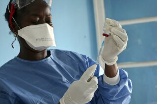 FILE - In this Wednesday, May 30, 2018 file photo, a healthcare worker from the World Health Organization prepares vaccines to give to front line aid workers, in Mbandaka, Congo. The vaccine allian...