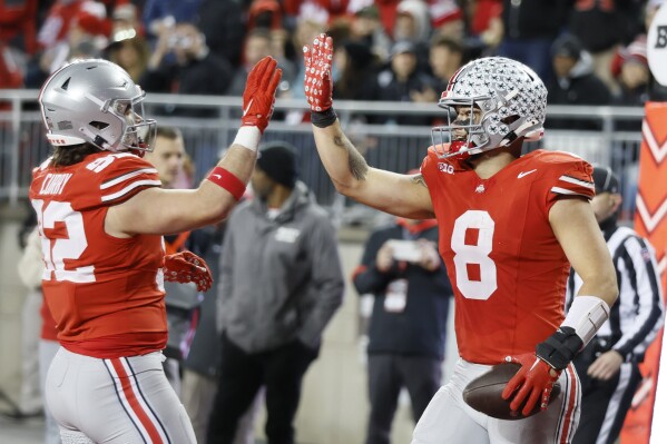 Ohio State tight end Cade Stover, right, celebrates after his touchdown against Minnesota with teammate defensive lineman Caden Curry during the second half of an NCAA college football game Saturday, Nov. 18, 2023, in Columbus, Ohio. (AP Photo/Jay LaPrete)