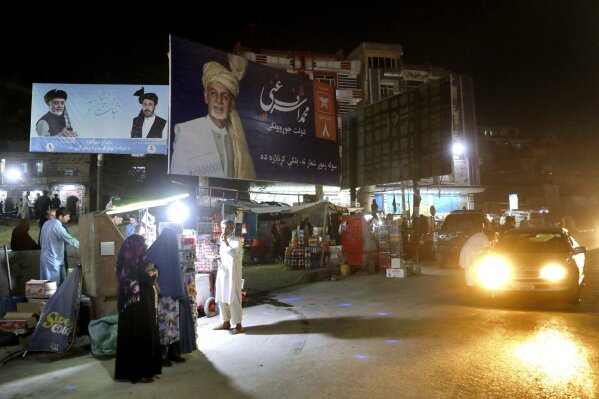 In this Tuesday, Sept. 24, 2019 photo, posters for presidential candidates Ashraf Ghani, center, and Abdullah Abdullah are displayed on the outskirts of Kabul, Afghanistan. Millions of Afghans are expected to go to the polls on Saturday to elect a new president, despite an upsurge of violence in the weeks since the collapse of a U.S.-Taliban deal to end America’s longest war, and the Taliban warning voters to say away from the polls. (AP Photo/Ebrahim Noroozi)
