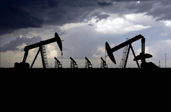 A thunderstorm passes between Midland and Odessa, Texas, just behind an array of pump jacks on Thursday, May 14, 2020. While the Inflation Reduction Act concentrates on clean energy incentives that could drastically reduce overall U.S. emissions, it also buoys oil and gas interests by mandating leasing of vast areas of public lands and off the nation’s coasts. (Eli Hartman/Odessa American via AP)
