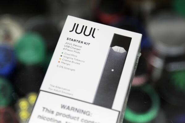 FILE - This Thursday, Dec. 20, 2018 file photo shows a Juul electronic cigarette starter kit at a smoke shop in New York. Altria reports its nearly $13 billion investment in troubled vaping company Juul is worth 95% less than it originally paid. The tobacco giant on Thursday, July 28, 2022,  said its stake in the e-cigarette maker is now worth less than $500 million after U.S. regulators announced plans to ban Juul's vaping devices.  (AP Photo/Seth Wenig)