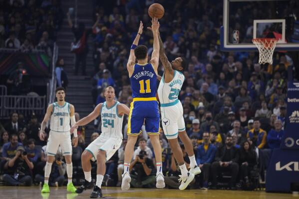 Golden State Warriors guard Klay Thompson (11) shoots a 3-point basket over Charlotte Hornets forward P.J. Washington during the first half of an NBA basketball game in San Francisco, Tuesday, Dec. 27, 2022. (AP Photo/Godofredo A. Vásquez)
