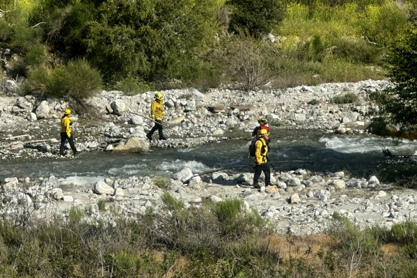 The San Bernardino County Fire Department conduct a swift water rescue of two children on Tuesday, May 7, 2024. Two young siblings who had been playing near Mill Creek by the Thurman Flats Picnic Area, in Mountain Home Village, Calif., died after being swept away by the rapidly flowing creek in Southern California's San Bernardino Mountains, authorities said. (John Lewis via AP)