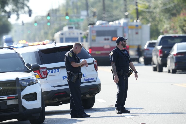 Jacksonville police officers block the perimeter of the scene of a mass shooting, Saturday, Aug. 26, 2023, in Jacksonville, Fla. (AP Photo/John Raoux)