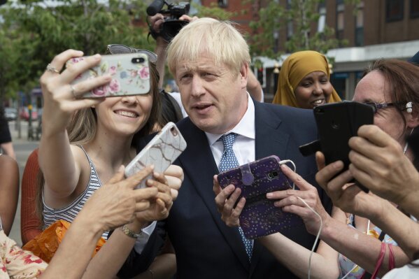 Britain's Prime Minister Boris Johnson on a walkabout during a visit to North Road, Birmingham, England, Friday, July 26, 2019. Johnson is making a plethora of promises that go well beyond Brexit: boosting police numbers, increasing school spending, improving internet speeds, even building electric planes. Johnson has not given details of where the money would come from to pay for these plans, though he has threatened to withhold a payment of 39 billion pounds ($49 billion) as part of a Brexit divorce bill that May agreed to if there is no deal. (Geoff Pugh/Pool Photo via AP)