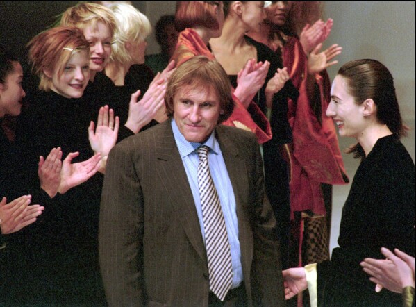 French actor Gerard Depardieu receives warm applause from the models at the unveiling of the Maska fashion show in Milan, Italy, Thursday, March 7, 1996. (AP Photo/Luca Bruno, File)