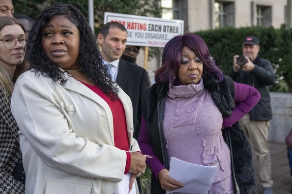 FILE - Wandrea "Shaye" Moss, left, and her mother Ruby Freeman, right, leave after speaking with reporters outside federal court, Friday, Dec. 15, 2023, in Washington. A jury awarded $148 million in damages on Friday to the two former Georgia election workers who sued Rudy Giuliani for defamation over lies he spread about them in 2020 that upended their lives with racist threats and harassment. (AP Photo/Alex Brandon, File)